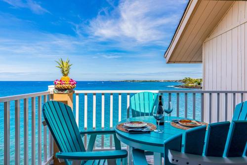 a table and chairs on a balcony with the ocean at The Sea Village #1302 in Kailua-Kona