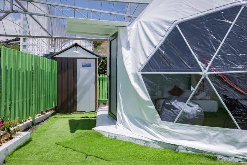 a tent in a garden with a bedroom inside at Glamz Hills in Cameron Highlands