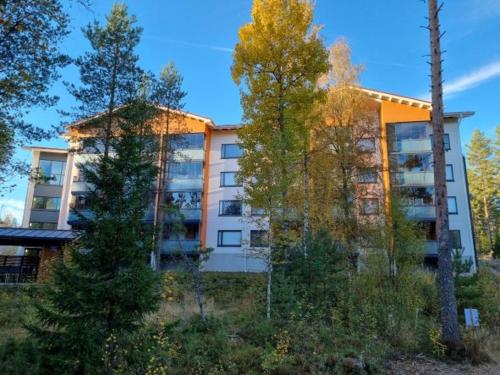um prédio de apartamentos com árvores em frente em Hyvin varusteltu yksiö 27 m² , Vierumäki Chalets 6 em Vierumäki