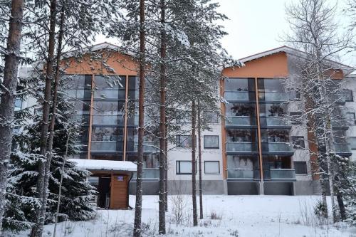 un edificio de apartamentos con árboles en la nieve en Hyvin varusteltu yksiö 27 m² , Vierumäki Chalets 6, en Vierumaki