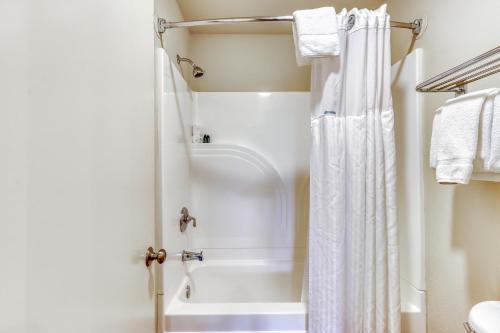 uma casa de banho com um chuveiro e uma cortina de chuveiro branca em Tree Top Retreat em Bend