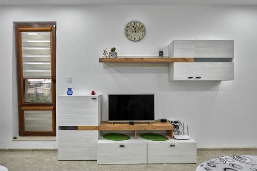 a living room with a tv on a white wall at Weiss Estate by EstateAutomata in Burgas City