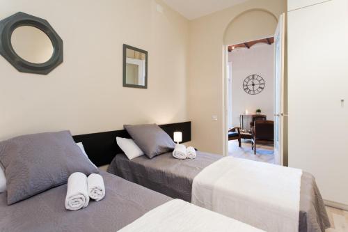 a bedroom with two beds and a mirror at Key Plaza Cataluña Bliss in Barcelona