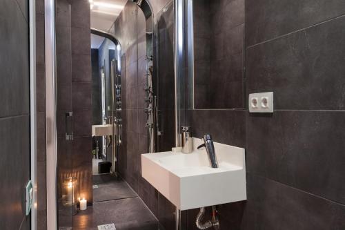 a bathroom with a white sink and a shower at Key Plaza Catalu&ntilde;a Bliss in Barcelona