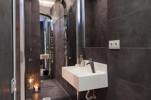 uma casa de banho com um lavatório branco e um chuveiro em Key Plaza Cataluña Bliss em Barcelona