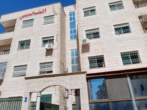 Al-Shokhaibie 51 Building- Soufan Studios في Ţāb Kirā‘: مبنى من الطوب وامامه قوس