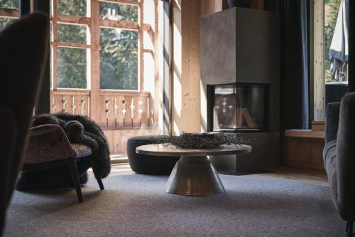a living room with a table and a fireplace at Tenne Lodges in Racines
