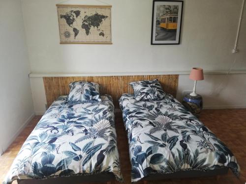 two beds sitting next to each other in a bedroom at Le gîte des Mégalithes in Le Bernard