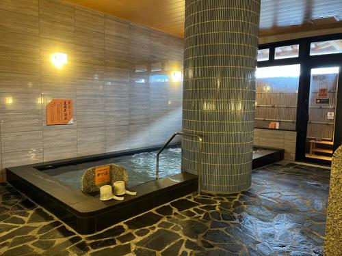 a bathroom with a tub with a stuffed animal in it at APA Hotel Joetsu Myoko-Ekimae in Joetsu