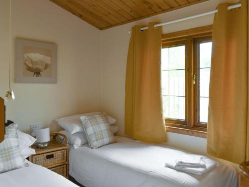 um quarto com 2 camas e uma janela em Llama Lodge em Otterford