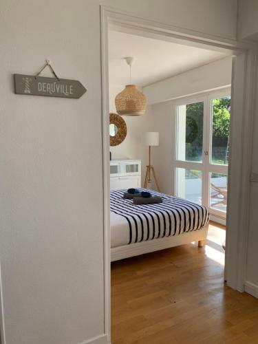 een slaapkamer met een bed en een bord met deville bij Trouville, appartement rénové avec grande terrasse au calme in Trouville-sur-Mer