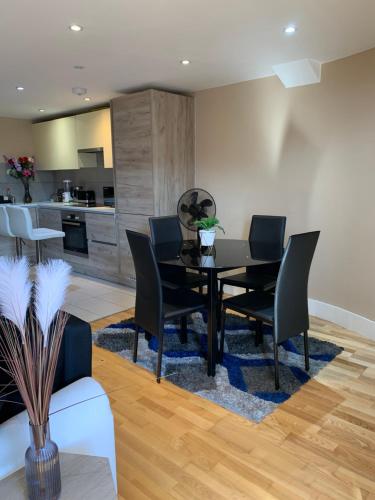 a dining room with a table and chairs and a kitchen at Entire 2 bedroom Apartment in Kingston upon Thames