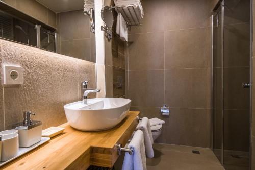 ein Badezimmer mit einem weißen Waschbecken und einer Dusche in der Unterkunft KALAMAKİ FLATS in Kaş