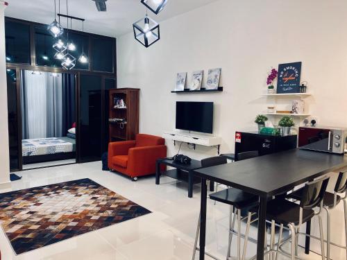 ein Wohnzimmer mit einem Tisch, einem Sofa und einem TV in der Unterkunft Airport KLIA Guest House (1 bedroom & 1 toilet) in Sepang