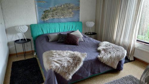 a bedroom with a bed with furry pillows on it at Countryside house Villa Pauliina -lomatalo in Jämijärvi