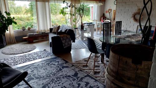 a living room with a couch and a table with chairs at Countryside house Villa Pauliina -lomatalo in Jämijärvi