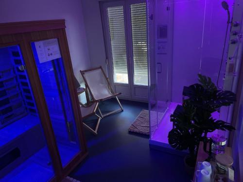 Cette chambre violette comprend un miroir et une chaise. dans l'établissement Hotel La Licorne, à Carnac