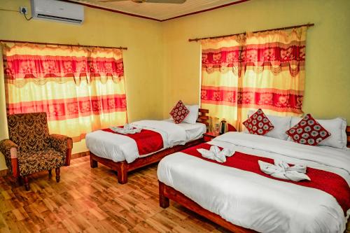 a bedroom with two beds and a chair in it at Hotel Plaza Nepal in Pokhara