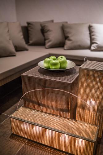 a plate of green apples on a table in a living room at Hotel Europa Lignano in Lignano Sabbiadoro