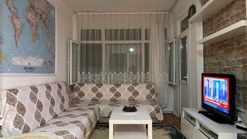 uma sala de estar com um sofá e uma televisão em Private room in old city em Istambul
