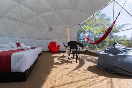 um quarto com uma cama e uma rede de descanso numa tenda em Glamz Hills em Cameron Highlands