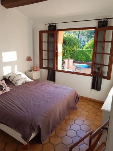 1 dormitorio con cama y ventana grande en Villa Eglantine, en Peymeinade