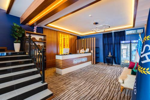 vestíbulo con escalera y paredes azules en Shahzoda Grand Hotel - "Best Hotel Award Winner", en Solnechnyy