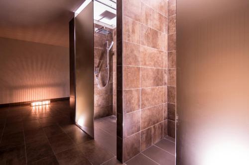 a shower stall in a bathroom with brown tiles at Hotel Europa Lignano in Lignano Sabbiadoro