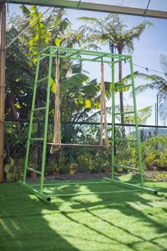 a green swing set sitting on the grass at Glamz Hills in Cameron Highlands