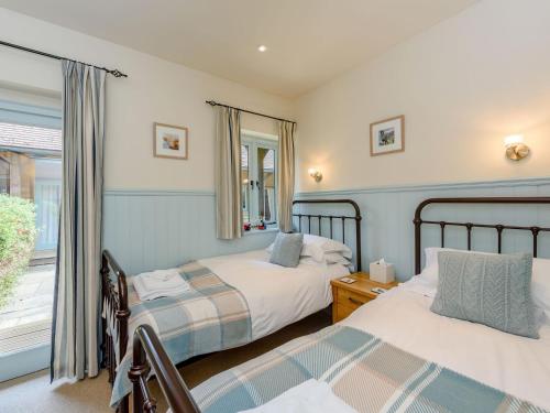 a bedroom with two beds and a window at Castlemans Stables West in Sedlescombe