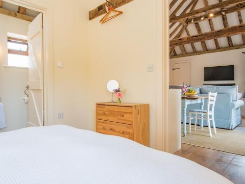 a bedroom with a bed and a table in a room at Shepherds Cottage in Pett