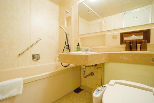 ein Badezimmer mit einem Waschbecken, einem WC und einer Badewanne in der Unterkunft Oehonke in Kitami