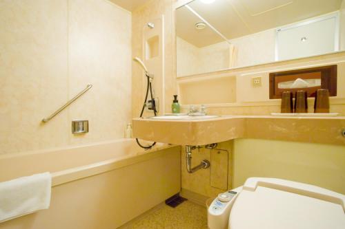 a bathroom with a sink and a toilet and a tub at Oehonke in Kitami