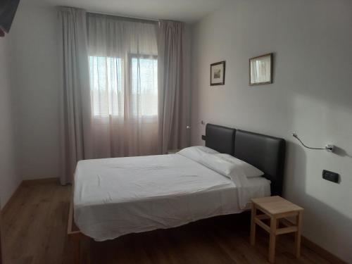 a bedroom with a white bed and a window at Gardafarm agriturismo in Verona
