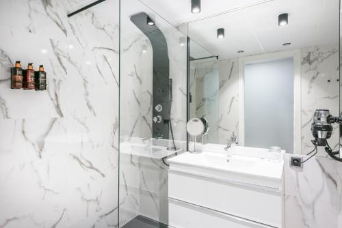 a bathroom with a shower and a sink and a mirror at Hotel Sansi Park in Lleida