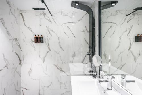 a white bathroom with a sink and a mirror at Hotel Sansi Park in Lleida