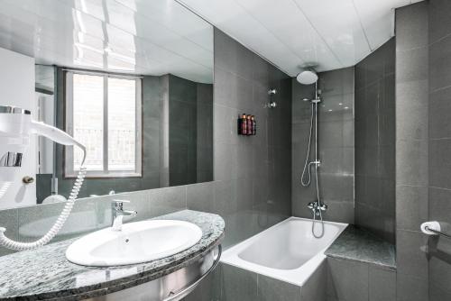 a bathroom with a sink and a bath tub at Hotel Sansi Park in Lleida