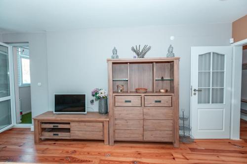 ein Wohnzimmer mit einem TV und einem Holzschrank in der Unterkunft COZY Home in Ruse