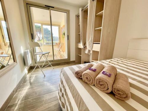 una camera da letto con un letto e asciugamani di Perle du Sud avec Parking Privé, piscine été dans Résidence calme a Sainte-Maxime