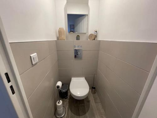 une petite salle de bain avec toilettes et miroir dans l'établissement Perle du Sud avec Parking Privé, piscine été dans Résidence calme, à Sainte-Maxime