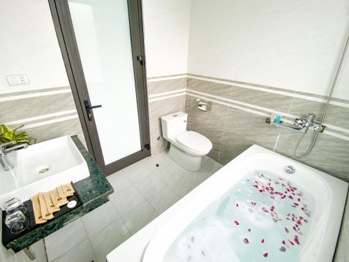 a bathroom with a tub and a sink and a toilet at Emopea Moc Chau in Mộc Châu