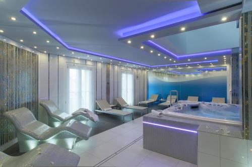 a bathroom with a jacuzzi tub and chairs at Arany Bárány Hotel in Zalaegerszeg