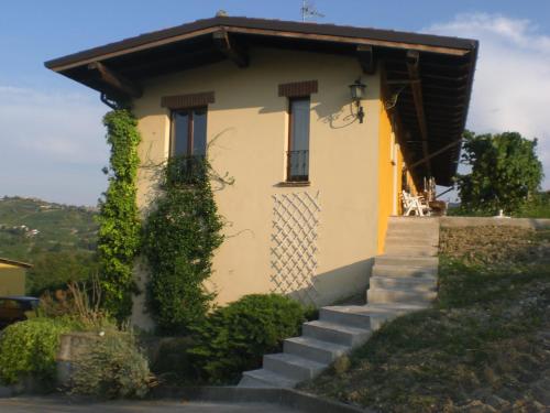 una pequeña casa amarilla con escaleras delante en Agriturismo Casa Re, en Santa Maria della Versa