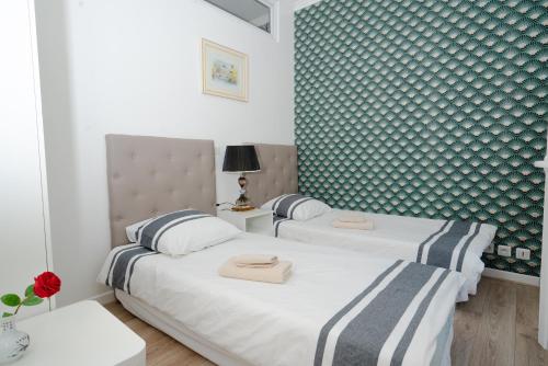 two beds in a room with blue and white wallpaper at Appartement de charme avec vue sur place de la République in Paris