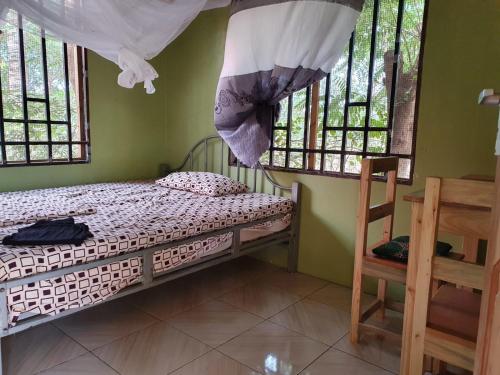 1 dormitorio con 1 cama en una habitación con ventanas en Eazy's Place, en Dar es Salaam