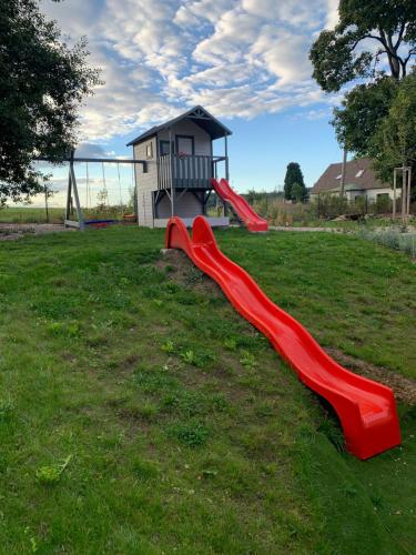 a playground with a red slide in a field at Vila Bohemia Saxon Switzerland & SPA in Šluknov