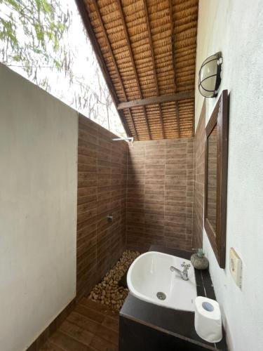 a bathroom with a sink and a bath tub at Black & White Cottages in Gili Trawangan