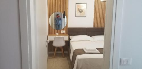 Una habitación de hotel con dos camas y un espejo. en White Apartment, en Tirana