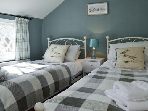 two beds sitting next to each other in a bedroom at Thwaite Cottage in Sigglesthorne