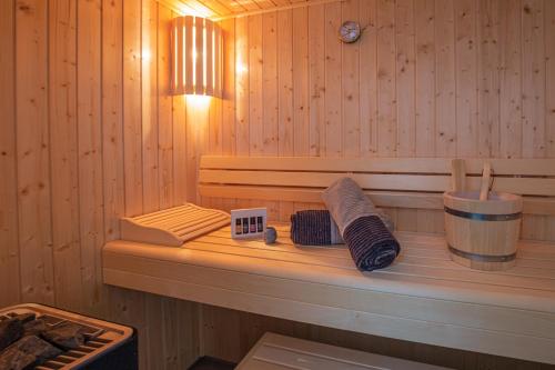 a sauna with a shelf with towels and a clock at Hansehaus 15, Grömitz in Grömitz